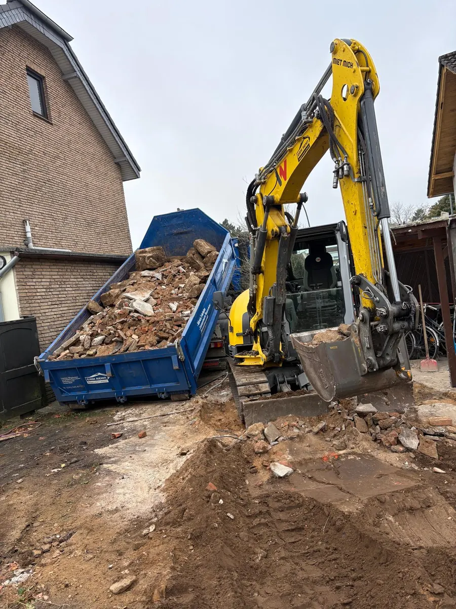 Wacker Neuson ET65 von Erik Rehn auf der geräumten Fläche in Neumünster, daneben der beladene Abrollcontainer