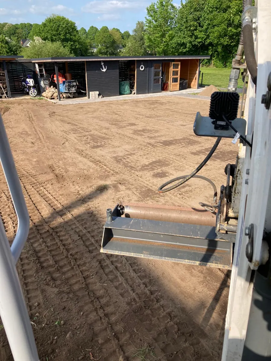 Planiergerät mit Glättwalze auf einer feinplanierten Gartenfläche