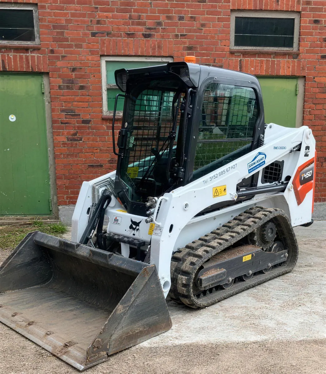 Bobcat T450 Kompaktlader aus dem Mietpark vor einem Backsteingebäude