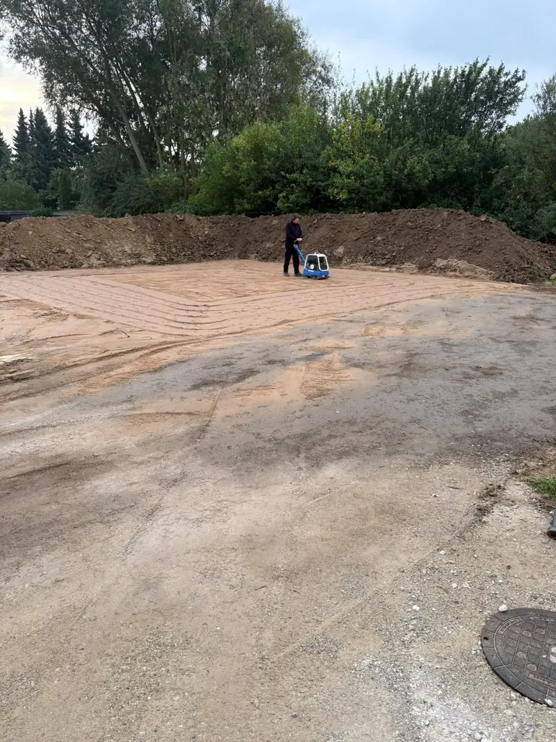 Verdichten der eingebauten Sandplatte mit der Rüttelplatte auf einem Baugrundstück in Ahrensbök